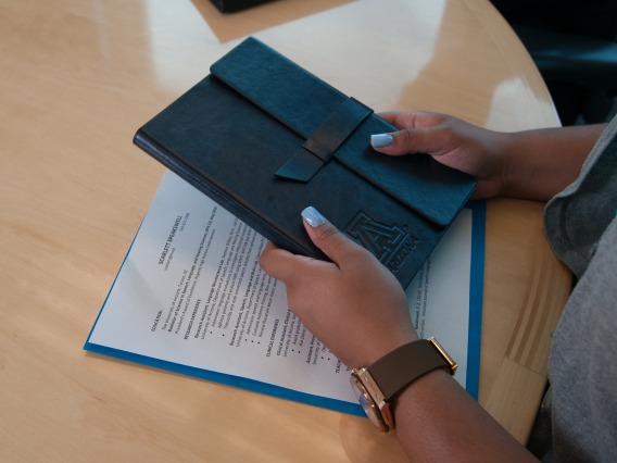 Two hands holding a leather booklet.