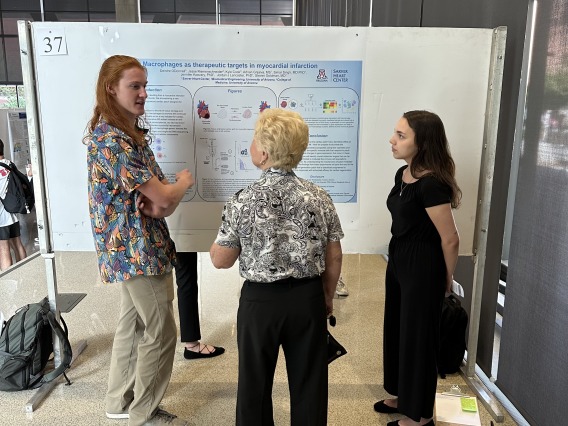 Three people standing around a research poster.
